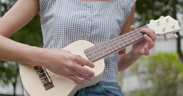 Woman play song on ukulele