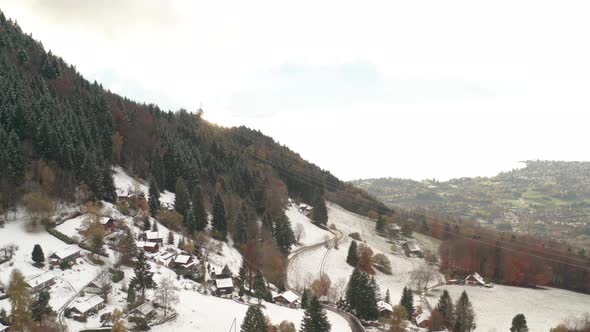 Jib down of small town in snow covered mountain