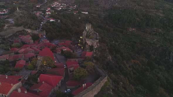 Drone aerial panorama of historic village of Sortelha with castle and with turbines on natural lands