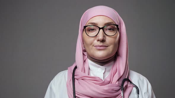 Young Lady Doctor in Hijab Smiles Widely Looking Into Camera