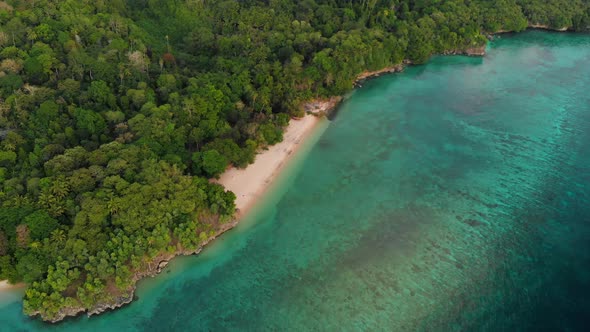 Aerial: flying over tropical Hatta island sand beach Banda Islands Indonesia