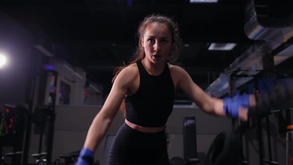 Athletic Young Woman Doing Some Crossfit Exercises with a Rope Indoor