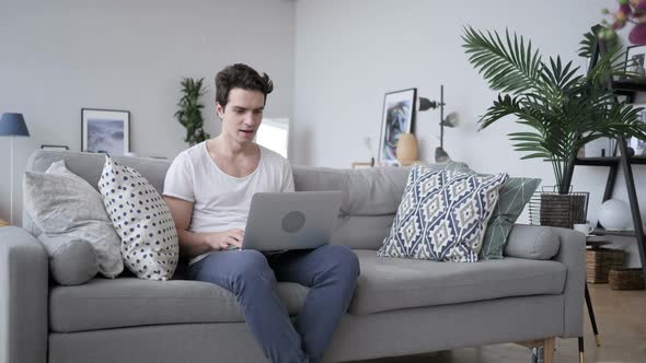 Excited Man Celebrating Success Working on Laptop