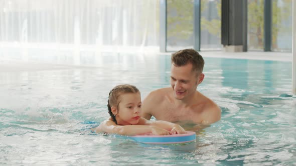 Man Teaching Daughter Swimming