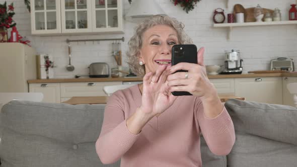 Pensioner Holds Telephone in Hand Smiles and Shows Cool Sign