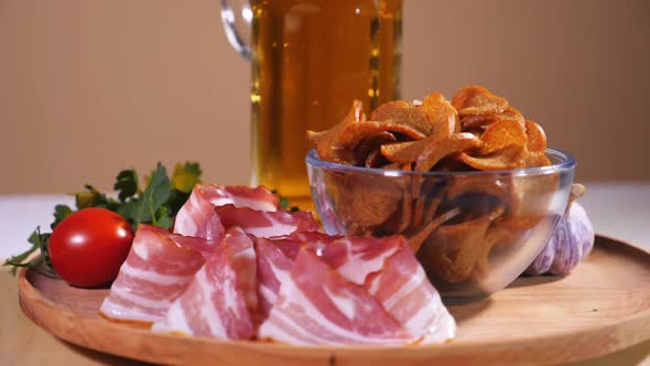 Tasty bread crackers, bacon, cherry tomatoes, greens and a glass of beer