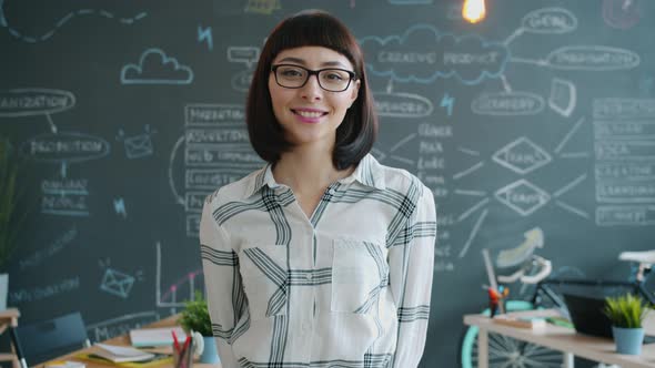 Portrait of Cute Girl Standing in Creative Office and Smiling Looking at Camera