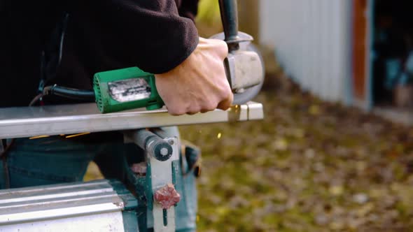 A married man cutting metal with angle grinder with sparks flying around in slowmotion