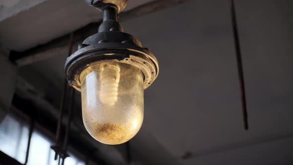 Explosionproof Lamp Hangs From Ceiling in Old Abandoned Factory