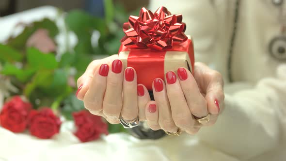 Female Manicured Hands with Gift Box.