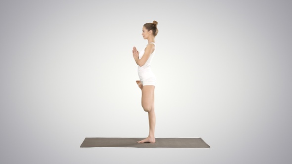 Young attractive woman practicing yoga doing tree exercise