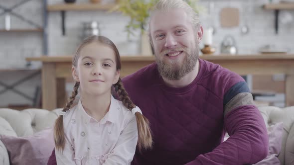 Close-up Portrait of Happy Caucasian Father and Daughter Looking at Camera and Smiling