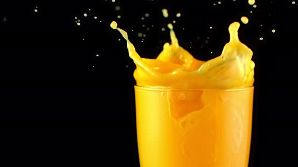 Super Slow Motion Shot of Ice Cubes Falling Into Glass of Orange Juice and Making Splash at 1000Fps