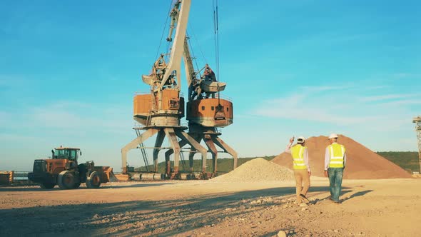 Quarry Zone with Mechanical Loaders and Two Engineers Talking