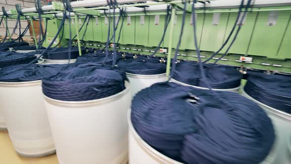 Industrial Machinery is Unreeling Bundles of Coloured Yarn