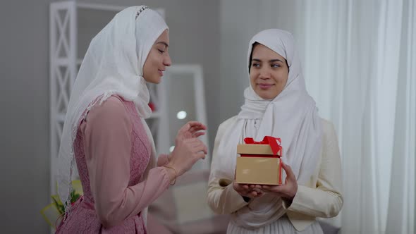 Confident Young Bride in Hijab Receiving Wedding Present From Bridesmaid