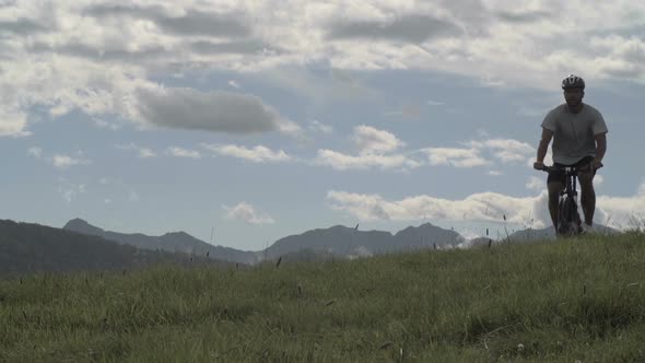 Young Athletic Man in Summer Day is Cycling Outdoor on Mountain with His Mountain Bike Slow Motion