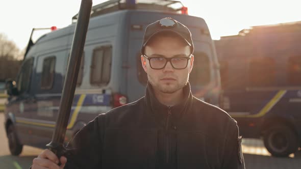 A Man in a Police Uniform is Turning His Head and Looking Seriously at the Camera