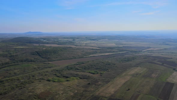 Aerial panorama in springtime field on hillside mountains near village in wonderful landscape