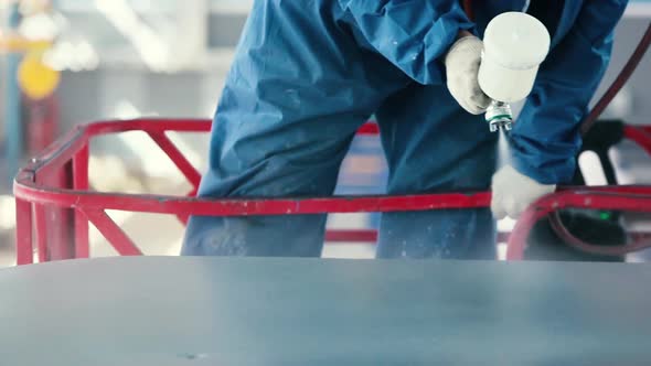 Worker Painting steel construction with Spray Pistol wearing mask