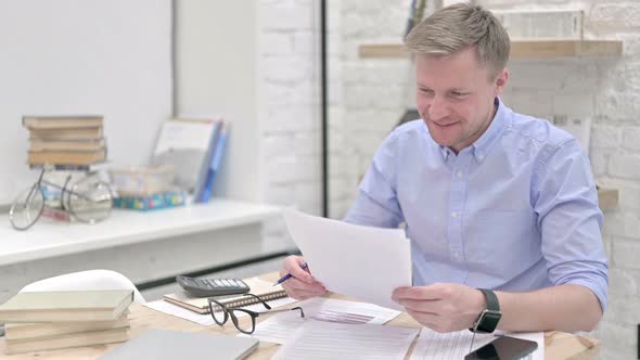 Excited Businessman Studying Documents