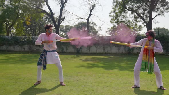 Indian men playing Holi using Pichkari and colors