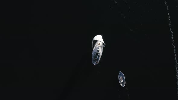 Flying Slowly Across Sailboat And A Small Fishing Boat In Bird's Eye View