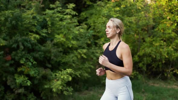 Athletic Woman Running Against Green Forest