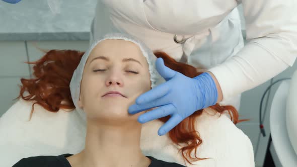 Gel the Woman's Face Before the Procedure in a Beauty Salon