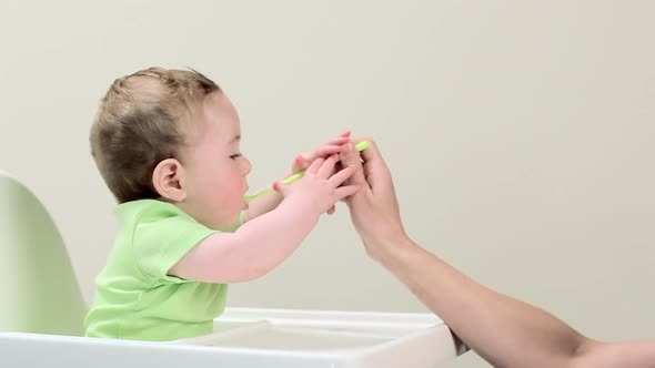 Baby boy sitting in highchair being fed