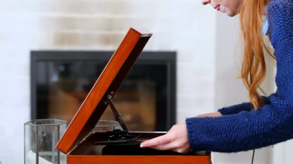 Beautiful woman adjusting compact disk in turntable 4k