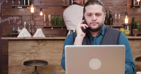 Ambitious Young Entrepreneur Making a Phone Call While in a Cafe