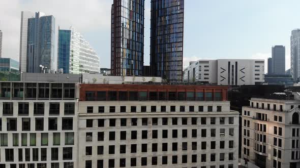 Raising up over Finsbury Park revealing tall skyscrapers near Liverpool Street Station in London