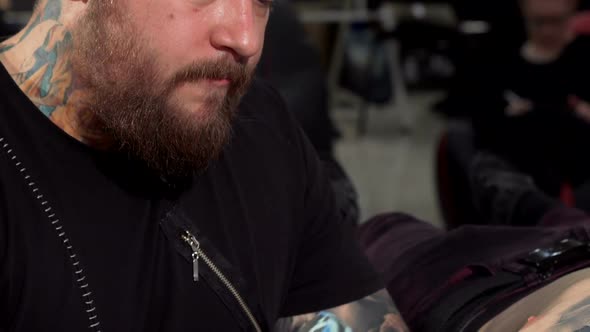 Sliding Shot of a Professional Tattoo Artist Working at His Tattoo Shop