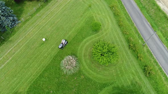 Riding lawn mower in action seen from the sky