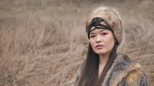 asian young woman in ethnic clothes close-up in the steppe in nature. Slow motion