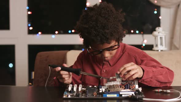 Surprised Black Boy Fixing Motherboard.