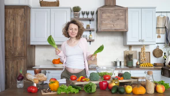 Happy Pregnancy Of Woman Dancing With Green Salad On Kitchen