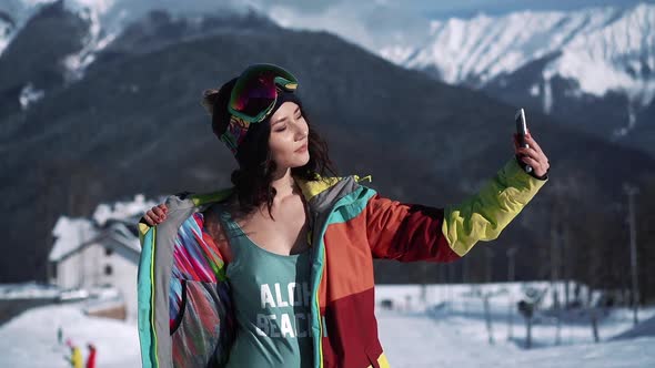 Asian Woman in Ski Snowboard Goggles and Sportswear Taking Selfie at Winter Ski Resort at Snowy