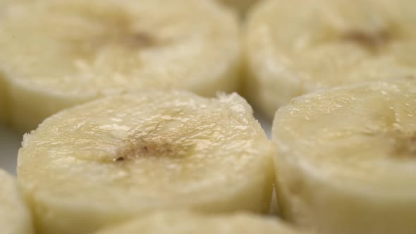 Banana Slices Closeup, Macro Food Summer Background, Fruits Top View. Rotate