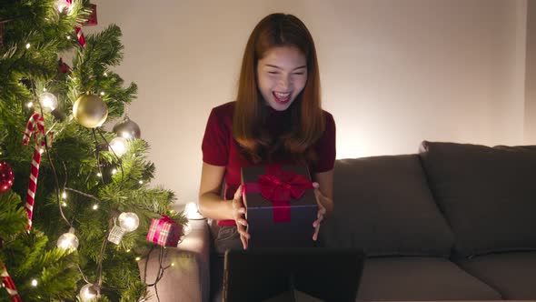 Young Asia female using tablet video call talking with couple with X'Mas present box
