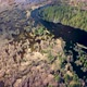 Aerial view of the river between the pines. Flying over a winding riverbed surrounded by treetops - VideoHive Item for Sale
