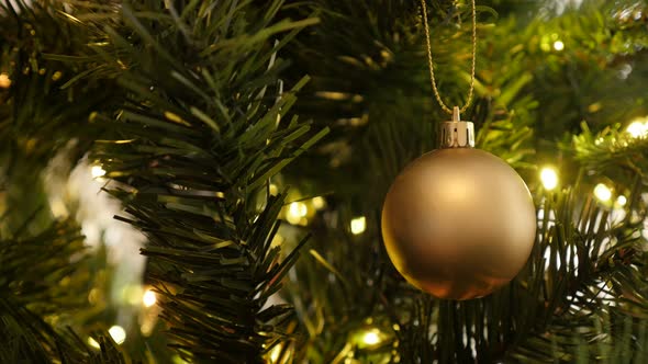 Close-up of Christmas ornament in golden matte color 4K 2160p 30fps UltraHD footage - Decorative lig