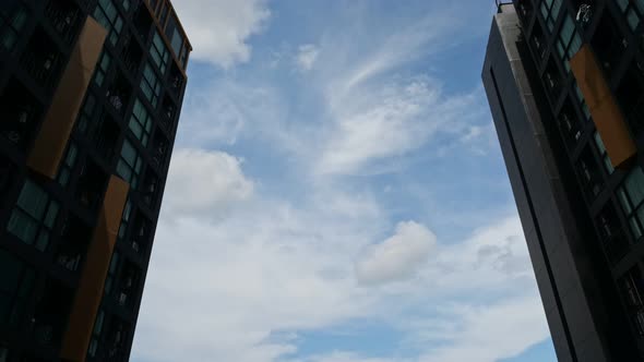 Clouds Float in Blue Sky Between Modern Buildings Timelapse