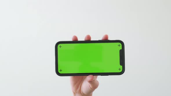 Hand holding smartphone with chroma key screen and showing on the white background