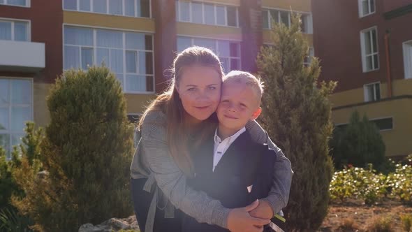 Portrait of a Mother and Son with a Backpack in Front of the School Building