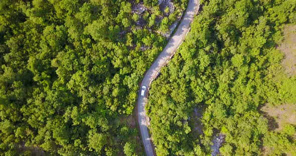 Aerial drone view of a minivan car vehicle driving on a rural road