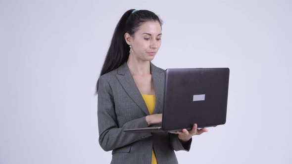 Happy Young Beautiful Businesswoman Thinking While Using Laptop