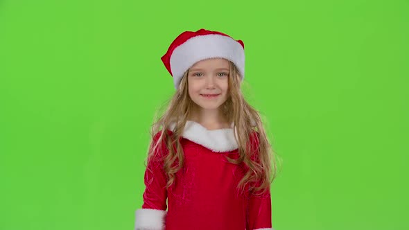 Child in Red Christmas Caps Send Air Kisses. Green Screen