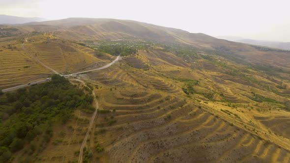 Aerial View of Cars Driving Along Empty Road on Hills in Armenia, Recreation